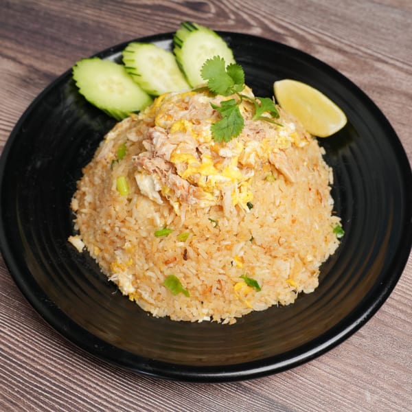 Luv2eat Thai Bistro's crab fried rice with cucumber slices, cilantro, and a lemon wedge.