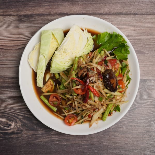 Som Tum Pu Pla Ra, a Thai papaya salad with fermented fish sauce, crab, and vegetables.