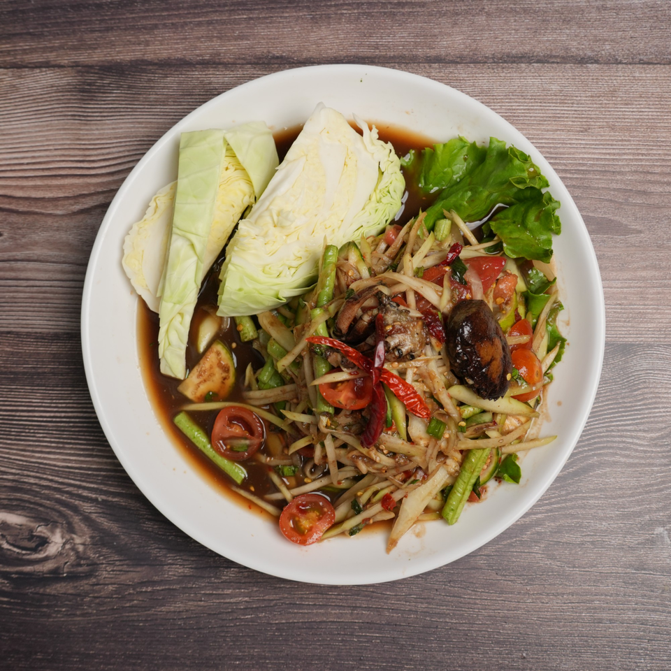 Som Tum Pu Pla Ra, a Thai papaya salad with fermented fish sauce, crab, and vegetables.